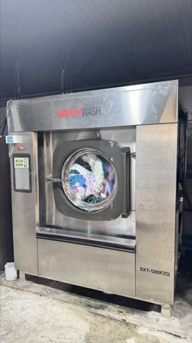 Industrial washer-extractor commissioned and running in an operating laundry plant