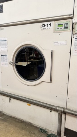 Industrial tumble dryer under service, access door open