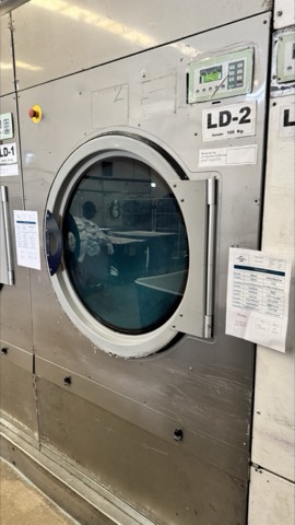 Serviced dryer bank in a healthcare laundry facility