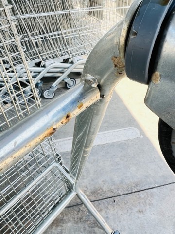 Close-up of a shopping-cart caster wheel and welded frame