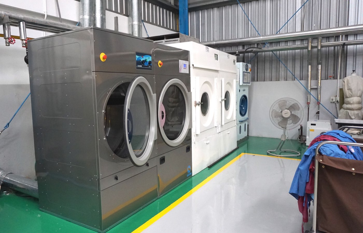 Bank of industrial drying machines in an operating laundry plant