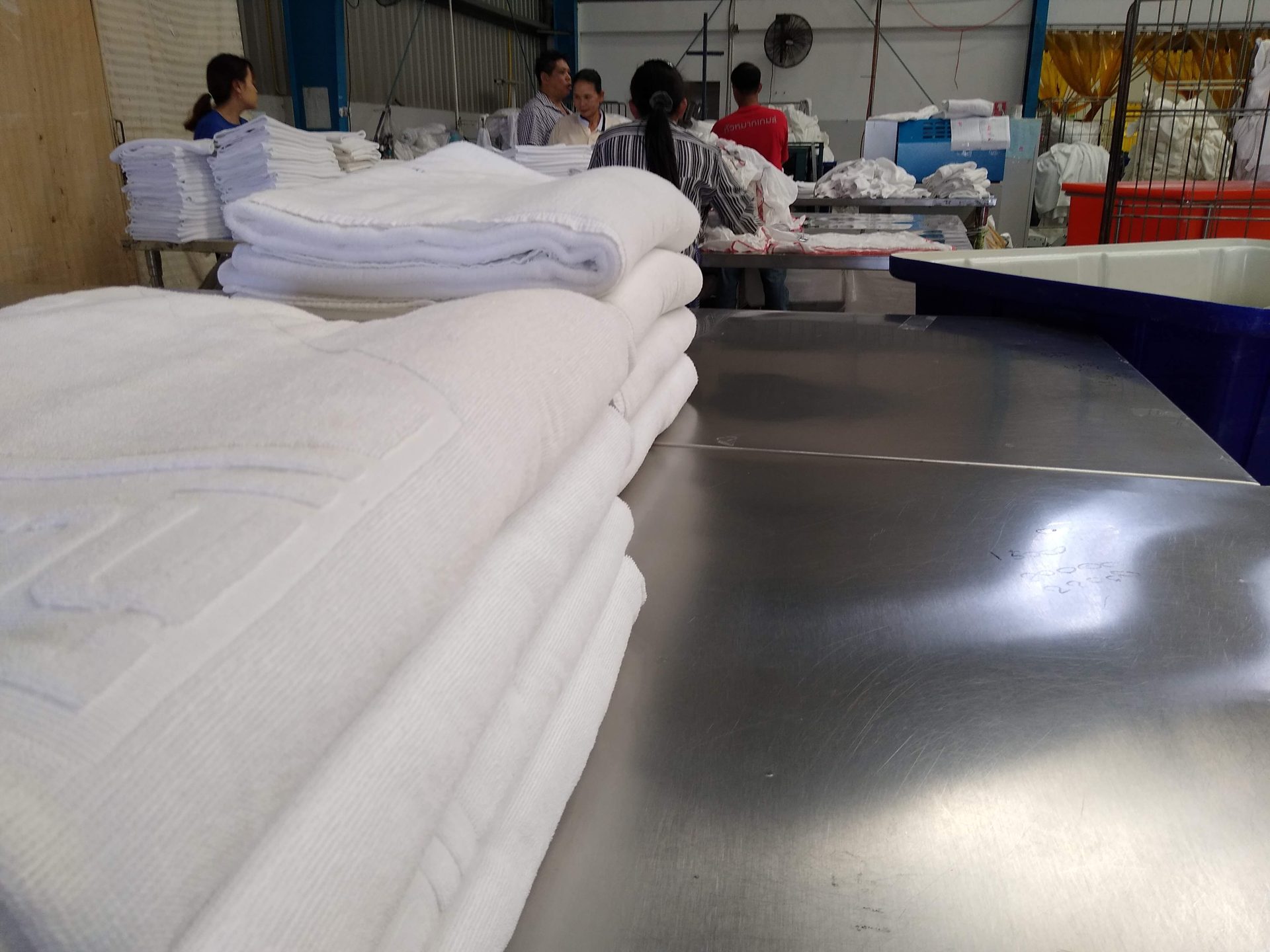 Stack of freshly laundered clean hospital linen after processing on the clean side of the flow