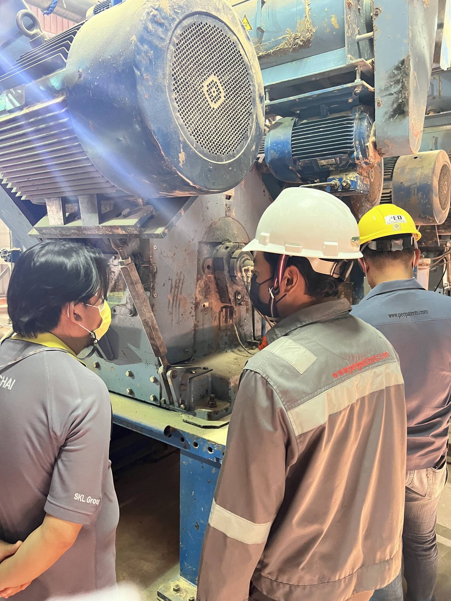 PEO Group engineers inspecting industrial laundry machinery on site