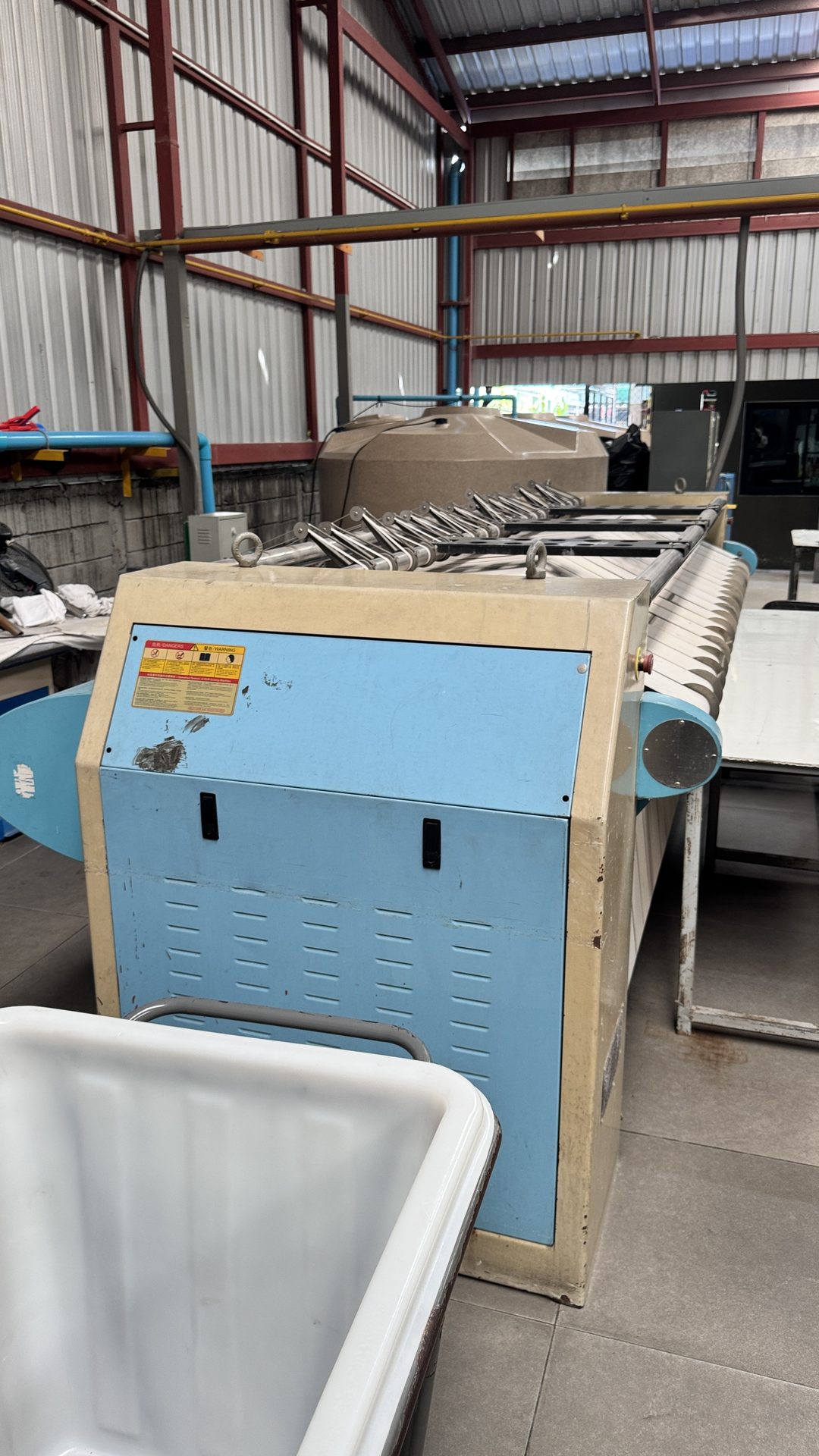 Large industrial flatwork ironer installed and running on PEO's laundry plant floor